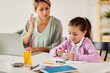 © Drazen - Little girl drawing while doing homework at the table.