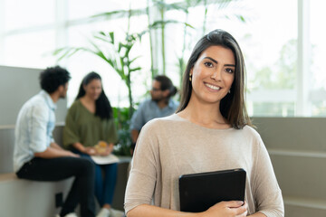 Portrait of latin female entrepreneur with big smile looking at camera inside coworking office. Communication, cooperation, attention  concept..