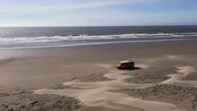 Aerial Drone Shot Of Yellow Camper Van Bus On Beach