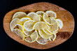 Ripe juicy yellow lemons slices on beautiful wood background. Prevention of colds in the cold season, ingredient for lemon tea or homemade lemonade.