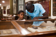 African American Father And Daughter Looking At Stands With Exhibits At Historical Museum