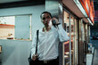 © THESHOTS.CO - Man use smartphone at corner in evening.