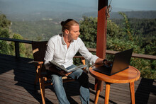 Rear View Of Male Traveler Blogger Work Remote On Laptop Computer While Enjoying Amazng Nature Moutains Landscape View Outdoors
