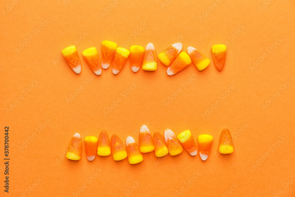 Tasty candies for Halloween on color background