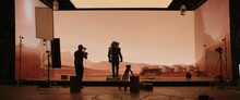 Behind The Scenes Shot Of Virtual Production Stage With Huge LED Screens, Cinematorgapher Shooting Mars Scene. Future Of Movie Production