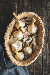 Sticker - White garlic bulbs in basket on old wooden table and napkin.