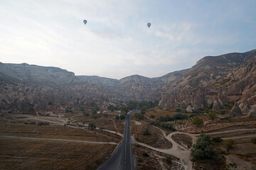 Wall Mural - Colorful hot air balloon ride and tour in Goreme valley, semi-arid region in central Turkey known for its distinctive fairy chimneys, tall, cone-shaped rock formation- Cappadocia, Turkey