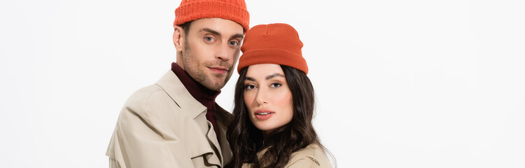 Poster - panoramic crop of trendy couple in beanie hats looking at camera isolated on white