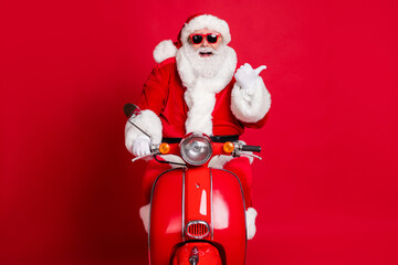 Poster - Photo of retired grandfather white beard ride retro moped direct thumb empty space propose look funny christmas decoration wear x-mas costume coat sunglass cap isolated red color background