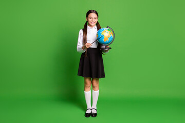 Canvas Print - Photo portrait of brunette schoolgirl pointing at africa on globe isolated on vivid green colored background