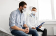 © Syda Productions - medicine, healthcare and pandemic concept - male doctor wearing face protective medical mask for protection from virus disease with clipboard and young man patient meeting at hospital