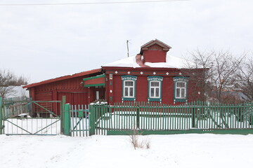 Old traditional national wooden house with richly decorated ornamental carved windows, frames in village (Moscow region, Russia). Russian folk style in architecture, countryside in Russia. Landmark