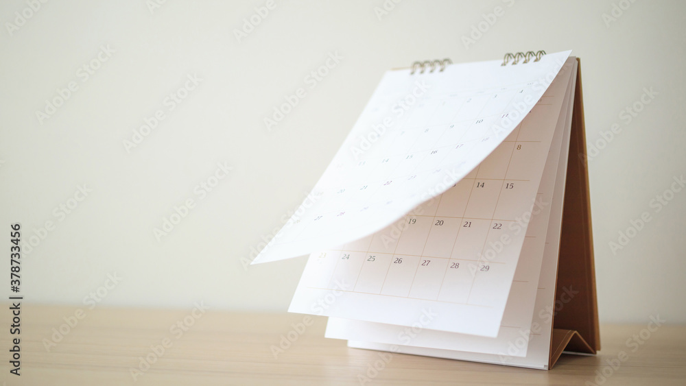 Calendar page flipping sheet on wood table background business schedule planning appointment meeting concept - obrazy, fototapety, plakaty 