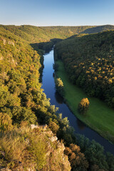 Wall Mural - Thaya river during summer or autumn time. Sunny day in the Thayatal Valley, National park, Lower Austria. Top view of the river with turns of meanders and green forests in bright sunlight. Nature 