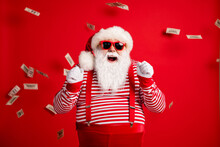 Photo of pensioner old man grey beard raise fists open mouth money shower wear santa x-mas costume suspenders sunglass gloves striped shirt cap isolated red color background