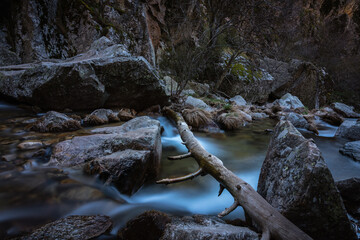 Wall Mural - River water flows among the rocks and forms small waterfalls, Rascafría, Madrid, Spain