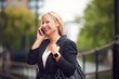 © Monkey Business - Mature Businesswoman Talking On Mobile Phone As She Walks Through City Street
