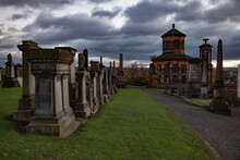 Glasgow / Scotland - Nov 13, 2013: Glasgow Necropolis Hill In Nasty Day. Grave Monuments And Mausoleum. Green Grass And Yellow Trees. Grey Storm Cloudy Sky. Panorama View.