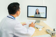 © ake1150 - Asian man doctor wears white coat and headset speaking videoconferencing on laptop computer using online video call consultation app. Remote medical help for distance patient, telemedicine..