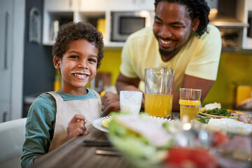 Happy child with father having fun at diner.