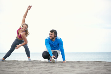 Wall Mural - Couple doing exercises on the beach