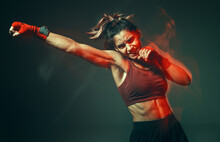 Cool Girl Fighter With Relief Abs Makes Jab In Studio In Neon Light. Sport And Motivation Concept. Long Exposure Shot