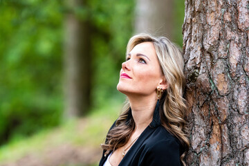 Wall Mural - portrait of a beautiful young woman posing near a tree