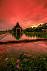 The background of the Wat Pa Kham Charoen is a beautiful old church with a Buddhist statue and a tree-lined temple, with tourists and travelers always making merit in Udon Thani, Thailand.