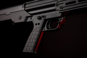 Sticker - Close up of a modern tactical pump action shotgun against a dark back. Red backlight.