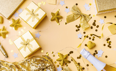  Top view of golden party decorations with confetti and gift boxes flat lay