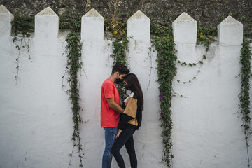 Poster - Affectionate couple standing by a decorated wall