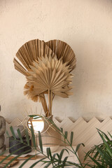 big beige palm leaves in boho style interior. bali decoration at home. travel concept, free space