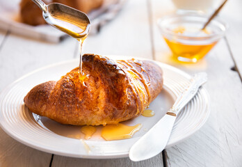 Fresh baked sweet croissants with jam or honey for breakfast