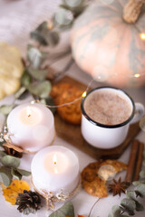 Wall Mural - Hot cocoa with cookies in a white mug surrounded by autumn leaves and pumpkins