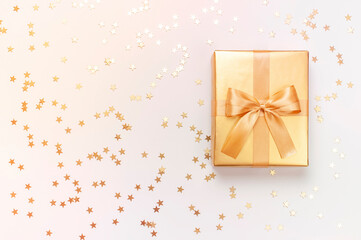 Wall Mural - New Year Christmas presents, golden gift with holiday ribbon, confetti stars on gray background top view. Flat lay Xmas holiday 2020 celebration. Gift boxes Festive decorations Surprise birthday