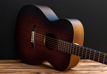 Wall Mural - Classical acoustic guitar lying down on floor near blackwall.