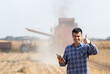 © Budimir Jevtic - Farmer with tablet in front of combine harvester in soybean field