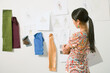 © SuperStock - Asian female fashion designer looking at drawings