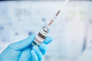 Covid-19 vaccine with syringe and  blue medical gloves