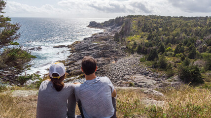 Wall Mural - Couple on a cliff looking at the rocky coastline in Maine United States