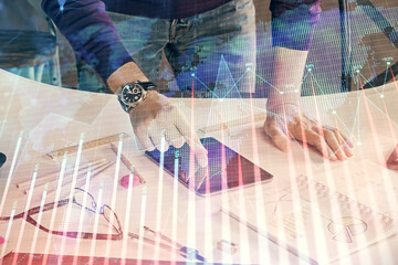 Double exposure of man's hands holding and using a digital device and forex graph drawing. Financial market concept.