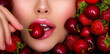 © Valua Vitaly - Attractive woman tasting cherry and strawberry. Beautiful woman with fashion makeup and a vivid background.