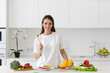 © BestForYou - Young beautiful woman preparing a salad of fresh vegetables in a bright kitchen.