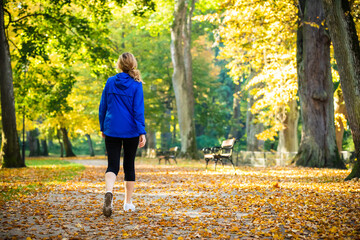 Wall Mural - middle-aged woman walking in city park