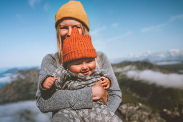 Family lifestyle baby with mother traveling together active healthy lifestyle vacation woman hiking with infant child in mountains of Norway