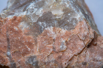 A close-up of a granite cobblestone interspersed with quartz under high magnification. Background with granite in soft focus.