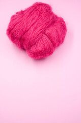 Canvas Print - Vertical shot of a ball of pink yarn on a pink surface