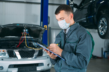 Wall Mural - mechanic maintaining car record on clipboard at the repair shop.