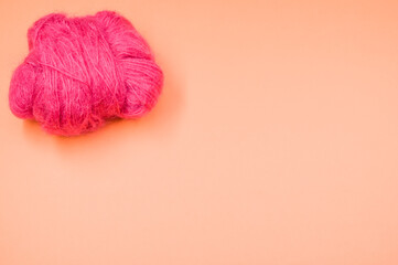 Canvas Print - High angle shot of a ball of pink yarn on an orange surface