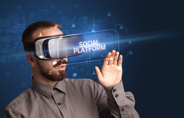 Businessman looking through Virtual Reality glasses with SOCIAL PLATFORM inscription, social networking concept